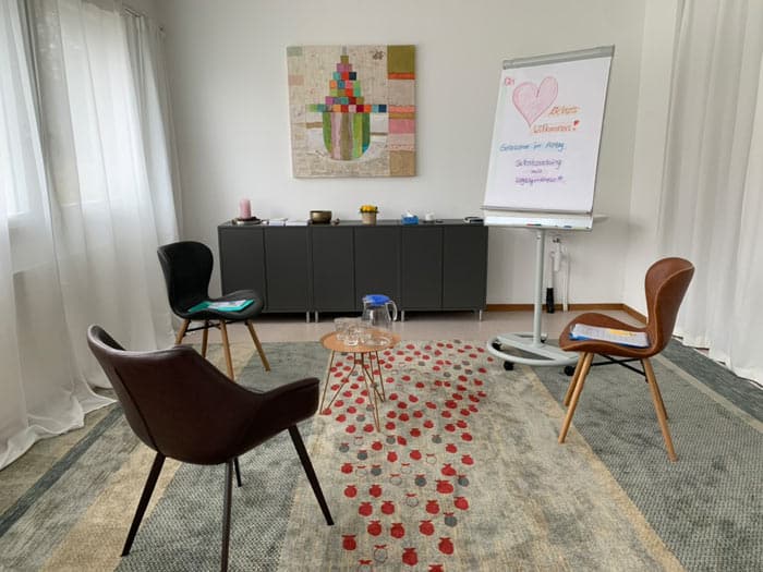 Blick in den freundlich wirkendenTherapieraum mit Stühlen, Flipchart.